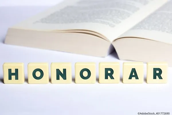 Feature-Bild: aufgeschlagenes Buch mit den Scabbel-Buchstaben Honorar davor